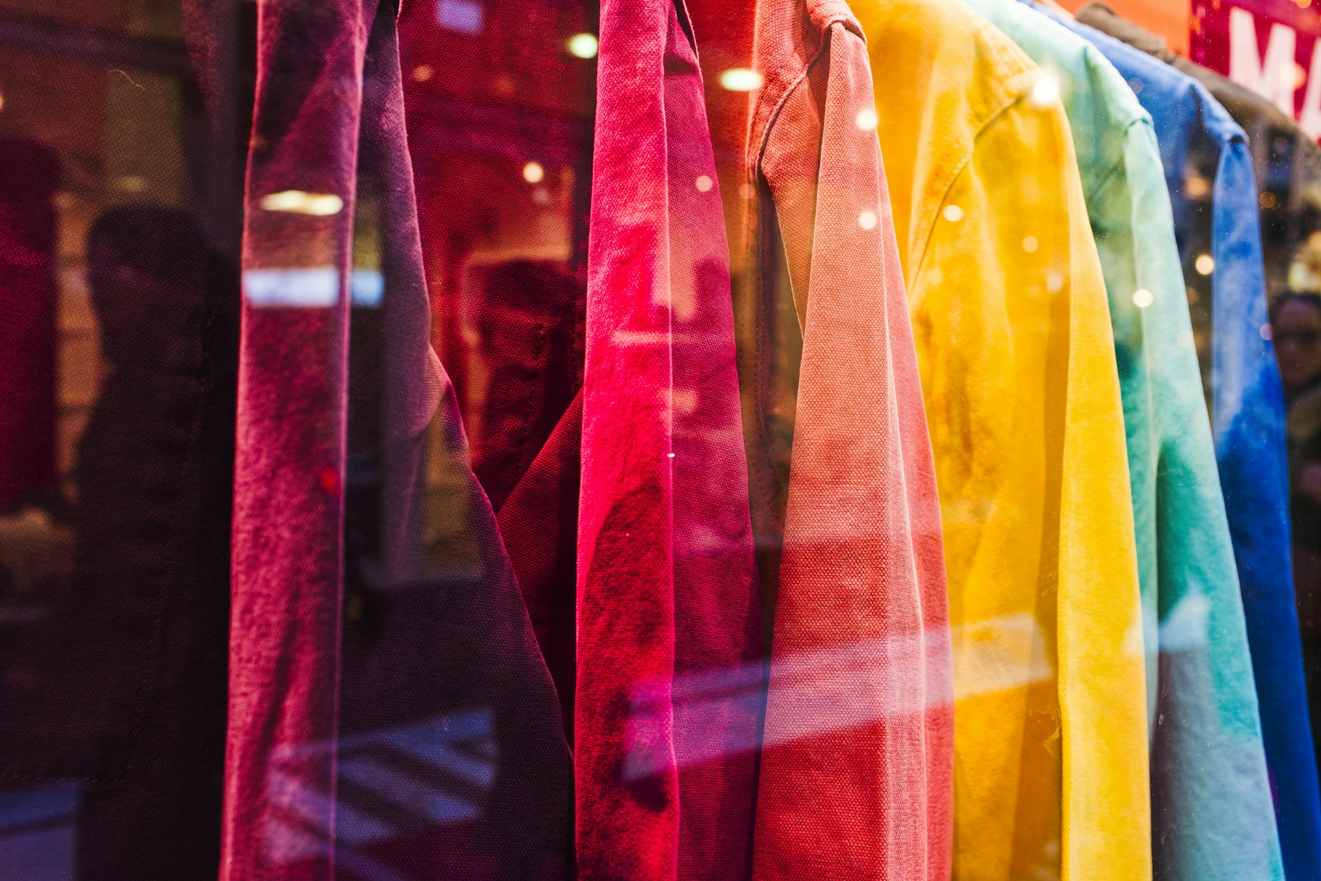 a row of colorful ties hanging in a store window